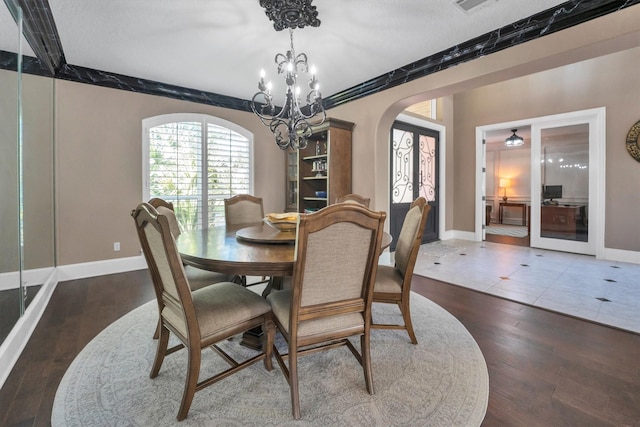 12710 Everhart Pointe Dr, Tomball, TX 77377 - dining room with arched walkways, baseboards, wood finished floors, and a chandelier