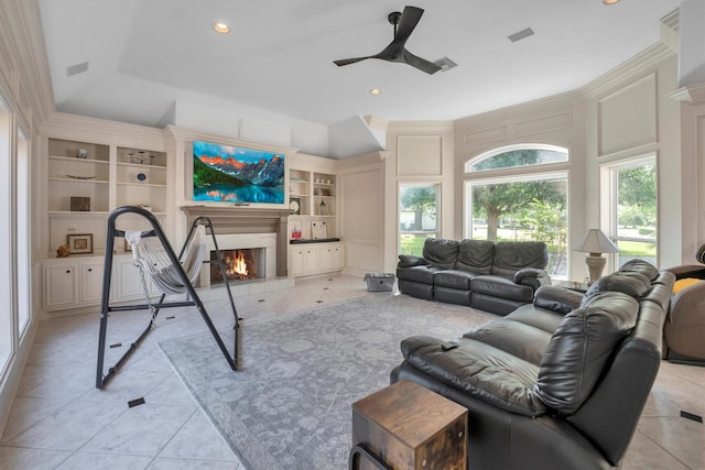 12710 Everhart Pointe Dr, Tomball, TX 77377 - living area featuring built in shelves, ceiling fan, a lit fireplace, light tile patterned floors, and recessed lighting