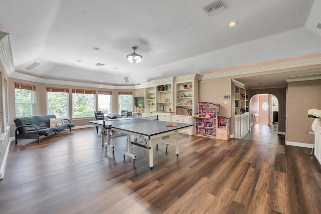 12710 Everhart Pointe Dr, Tomball, TX 77377 - playroom with a raised ceiling, arched walkways, crown molding, dark wood-style flooring, and baseboards