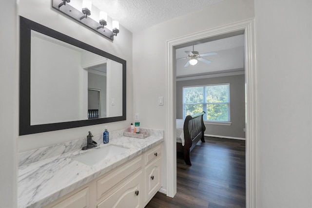 12710 Everhart Pointe Dr, Tomball, TX 77377 - bathroom with wood finished floors, vanity, a textured ceiling, a ceiling fan, and baseboards