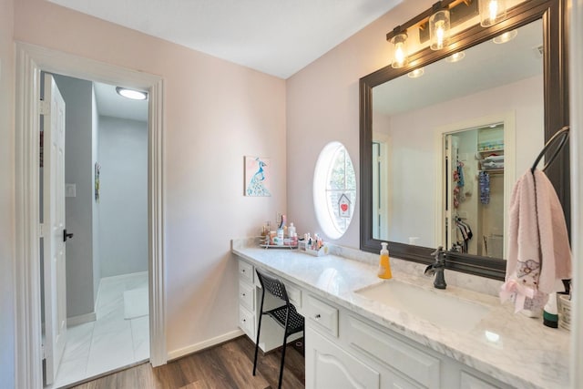 12710 Everhart Pointe Dr, Tomball, TX 77377 - bathroom with vanity, baseboards, wood finished floors, and a walk in closet