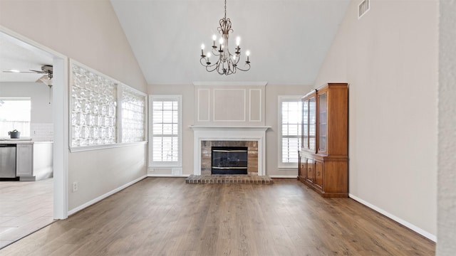 16902 River Willow Dr, Spring, TX 77379 - unfurnished living room with a brick fireplace, wood finished floors, ceiling fan, a chandelier, and high vaulted ceiling