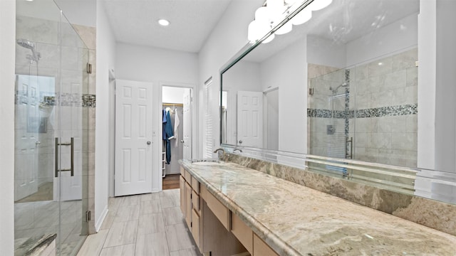 16902 River Willow Dr, Spring, TX 77379 - bathroom with a stall shower, a spacious closet, vanity, and recessed lighting