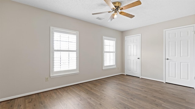 16902 River Willow Dr, Spring, TX 77379 - unfurnished bedroom with baseboards, wood finished floors, a textured ceiling, and ceiling fan