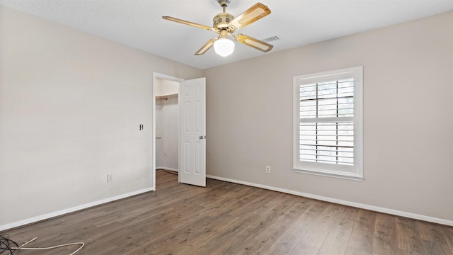 16902 River Willow Dr, Spring, TX 77379 - unfurnished bedroom featuring wood finished floors, baseboards, ceiling fan, and a spacious closet
