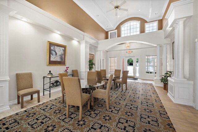 2111 Welch St Unit B212, Houston, TX 77019 - dining space featuring decorative columns, plenty of natural light, a ceiling fan, light wood-style floors, and high vaulted ceiling