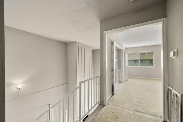 hallway with carpet floors and baseboards