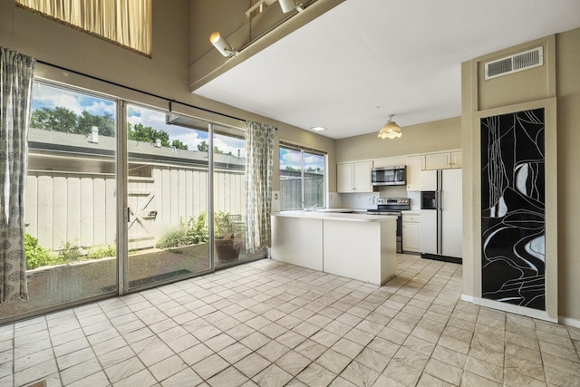 kitchen featuring stainless steel appliances, white cabinetry, a peninsula, and light countertops