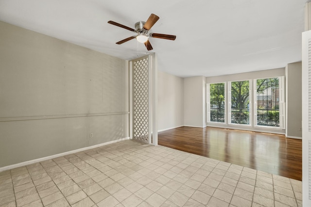 spare room with ceiling fan, baseboards, and wood finished floors