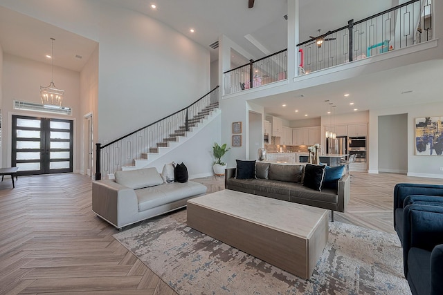 27807 Bridgeway St, Spring, TX 77386 - living room with a high ceiling, a chandelier, baseboards, stairs, and french doors