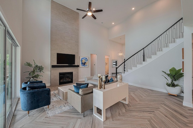 27807 Bridgeway St, Spring, TX 77386 - living area with a towering ceiling, stairway, ceiling fan, a large fireplace, and baseboards