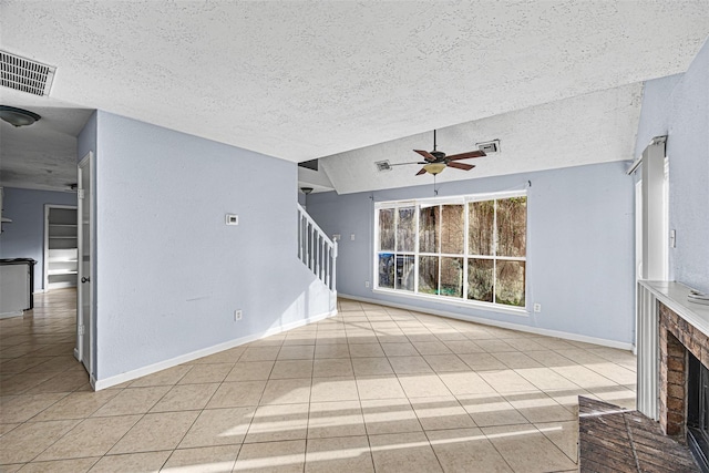 17607 Northfalk Dr, Houston, TX 77084 - unfurnished living room with a textured ceiling, tile patterned floors, ceiling fan, a brick fireplace, and stairs