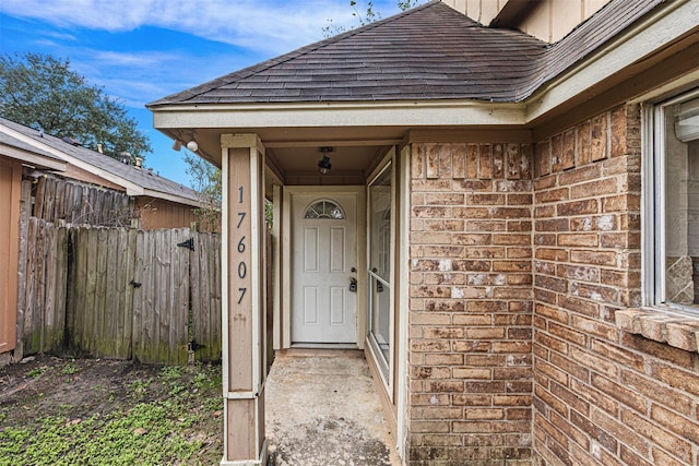 17607 Northfalk Dr, Houston, TX 77084 - property entrance with brick siding, fence, and roof with shingles