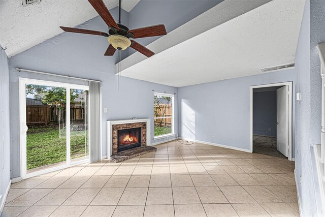 17607 Northfalk Dr, Houston, TX 77084 - unfurnished living room with light tile patterned floors, plenty of natural light, a ceiling fan, lofted ceiling, and a fireplace