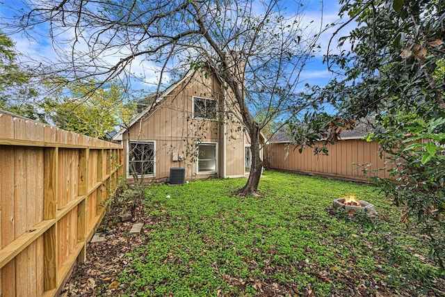 17607 Northfalk Dr, Houston, TX 77084 - rear view of property with an outdoor fire pit, central AC, and an outbuilding