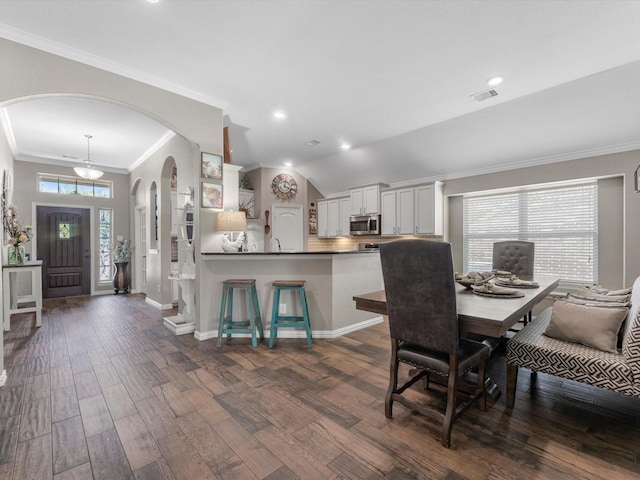 1326 Tee Time Ct, Crosby, TX 77532 - dining area featuring dark wood-type flooring, baseboards, crown molding, arched walkways, and recessed lighting