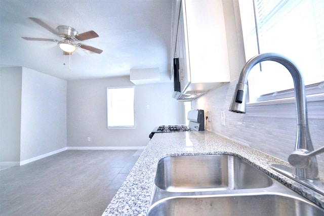6534 Ledbetter St, Houston, TX 77087 - kitchen featuring gas range oven, a sink, backsplash, light stone counters, and ceiling fan