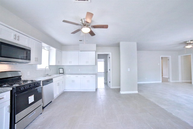 6534 Ledbetter St, Houston, TX 77087 - kitchen featuring stainless steel appliances, ceiling fan, open floor plan, and white cabinets