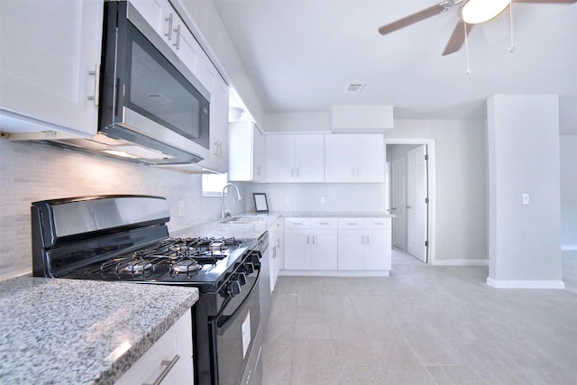 6534 Ledbetter St, Houston, TX 77087 - kitchen featuring black gas range oven, stainless steel microwave, a sink, backsplash, and ceiling fan