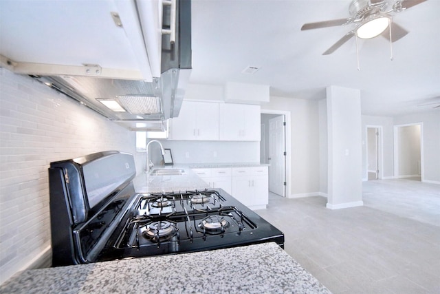 6534 Ledbetter St, Houston, TX 77087 - kitchen featuring a sink, range with gas stovetop, a ceiling fan, white cabinets, and light stone countertops