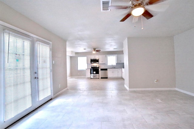 6534 Ledbetter St, Houston, TX 77087 - unfurnished living room with a ceiling fan, baseboards, and light tile patterned flooring