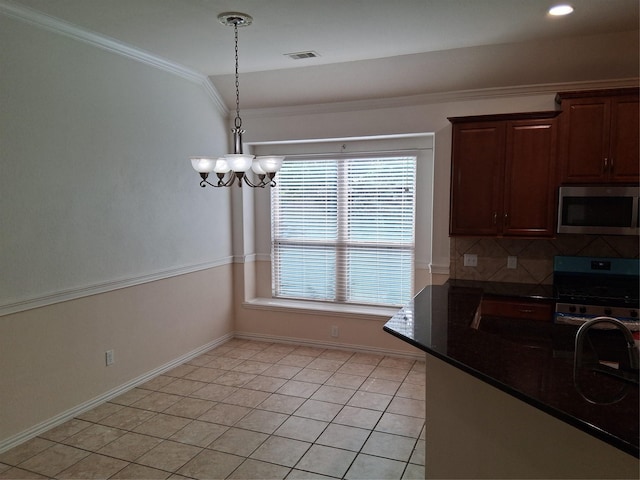24911 Tribeca Ln, Katy, TX 77493 - kitchen with appliances with stainless steel finishes, crown molding, a chandelier, light tile patterned flooring, and baseboards