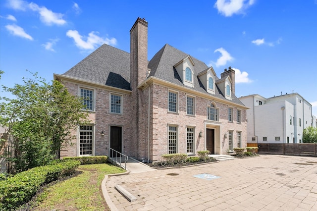 6104 San Felipe St, Houston, TX 77057 - view of front of home featuring brick siding, a chimney, fence, and roof with shingles