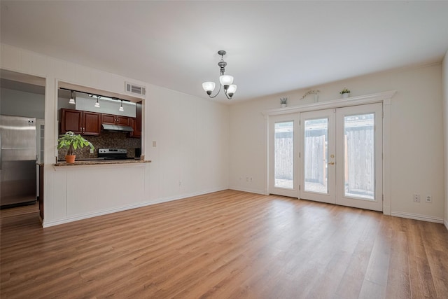 13040 Trail Hollow Dr Unit 3040, Houston, TX 77079 - unfurnished living room featuring light wood-style floors, a chandelier, rail lighting, and baseboards