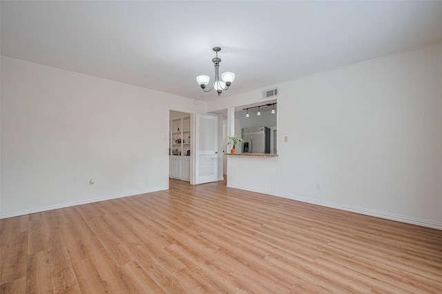 13040 Trail Hollow Dr Unit 3040, Houston, TX 77079 - unfurnished living room featuring a chandelier, light wood-style floors, and baseboards