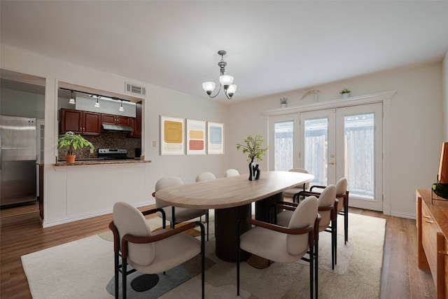 13040 Trail Hollow Dr Unit 3040, Houston, TX 77079 - dining room with light wood-style floors, a chandelier, and french doors