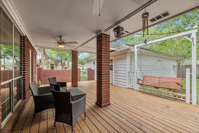 wooden deck featuring ceiling fan and fence
