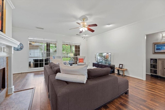 living room featuring wood finished floors, a ceiling fan, a premium fireplace, crown molding, and baseboards