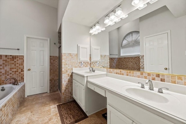 full bathroom with tile walls, a garden tub, double vanity, a wainscoted wall, and tile patterned flooring