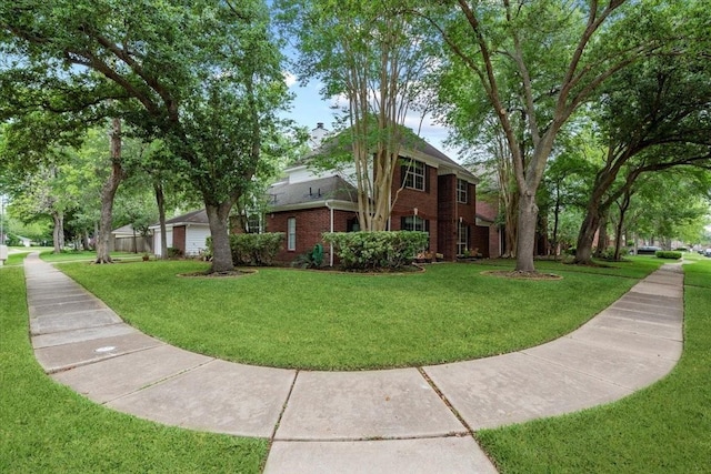 view of side of home featuring brick siding and a yard