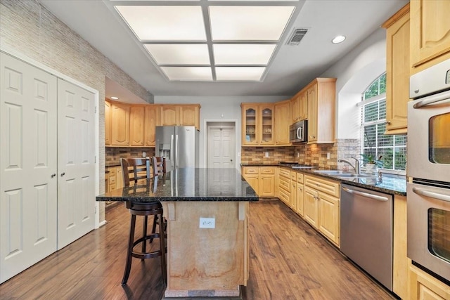 kitchen featuring stainless steel appliances, a sink, light brown cabinets, dark wood finished floors, and recessed lighting