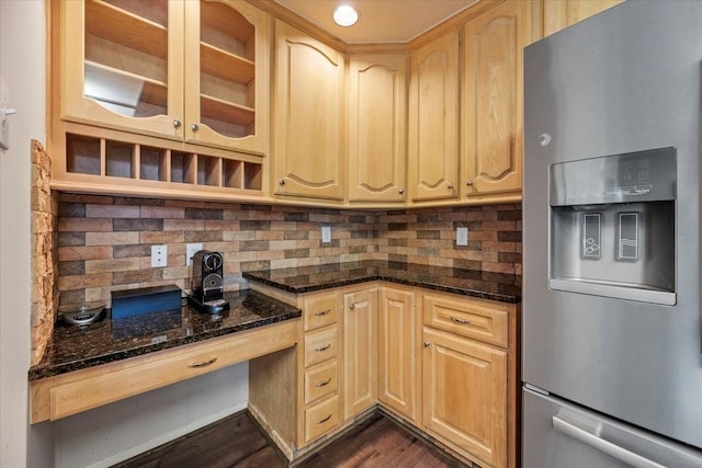 kitchen featuring stainless steel fridge with ice dispenser, light brown cabinets, tasteful backsplash, and dark stone countertops