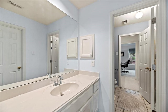 bathroom with vanity, toilet, and tile patterned floors