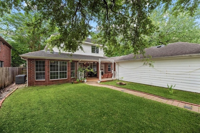 back of house featuring central AC, brick siding, and a deck