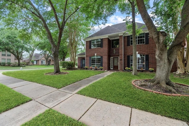 view of front of property featuring a front yard and brick siding