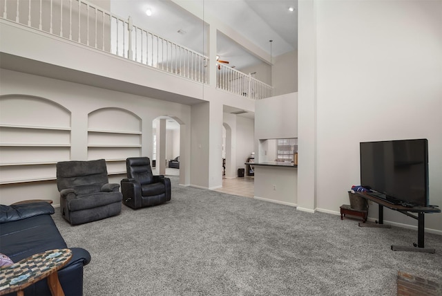 1409 Cherokee St, Deer Park, TX 77536 - carpeted living room featuring arched walkways, a ceiling fan, a towering ceiling, and baseboards