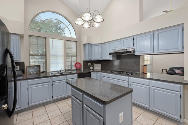 1409 Cherokee St, Deer Park, TX 77536 - kitchen with a sink, under cabinet range hood, dark countertops, high vaulted ceiling, and stainless steel gas stovetop