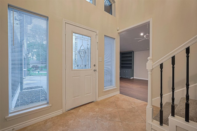 520 S Rivershire Dr, Conroe, TX 77304 - entryway with tile patterned floors, stairway, baseboards, and a ceiling fan