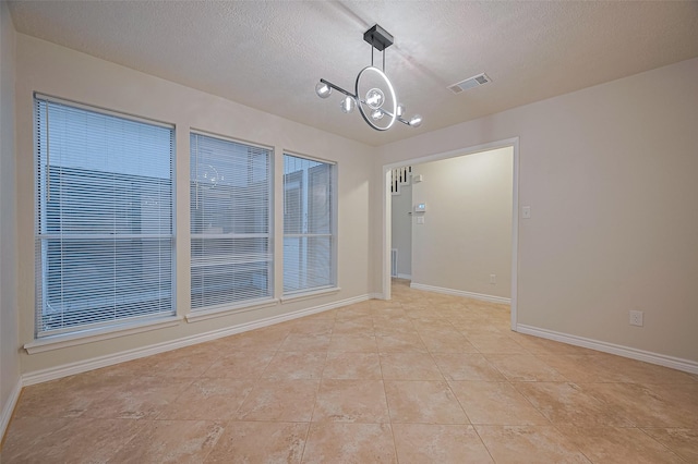 520 S Rivershire Dr, Conroe, TX 77304 - empty room featuring a chandelier, light tile patterned flooring, baseboards, and a textured ceiling