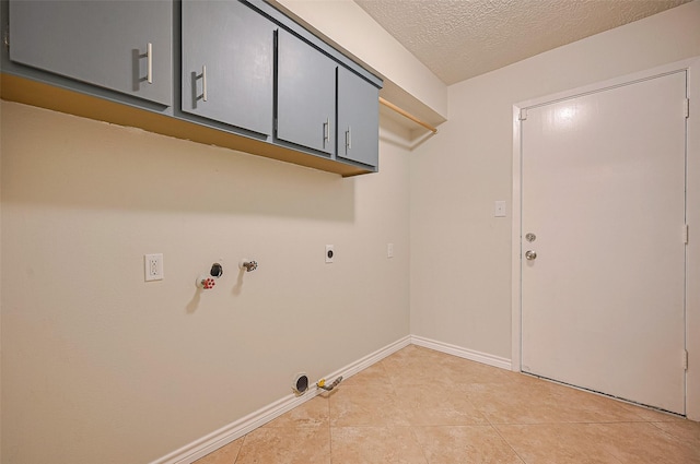 520 S Rivershire Dr, Conroe, TX 77304 - clothes washing area featuring gas dryer hookup, cabinet space, hookup for an electric dryer, light tile patterned flooring, and a textured ceiling