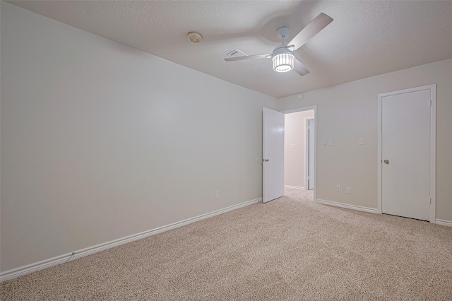 520 S Rivershire Dr, Conroe, TX 77304 - unfurnished bedroom featuring light colored carpet, baseboards, a textured ceiling, and a ceiling fan