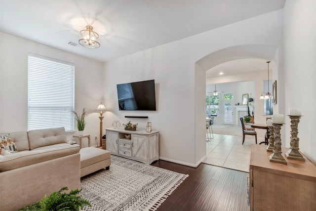17219 Rookery Ct, Conroe, TX 77385 - living area with arched walkways, a chandelier, dark wood-type flooring, and baseboards