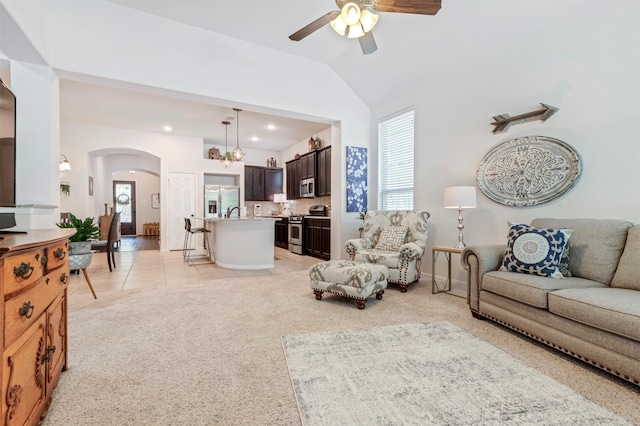 17219 Rookery Ct, Conroe, TX 77385 - living room featuring arched walkways, healthy amount of natural light, ceiling fan, light carpet, and lofted ceiling