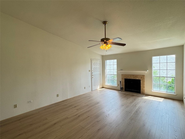 7400 Bellerive Dr Unit 1004, Houston, TX 77036 - unfurnished living room featuring wood finished floors, plenty of natural light, ceiling fan, and a premium fireplace