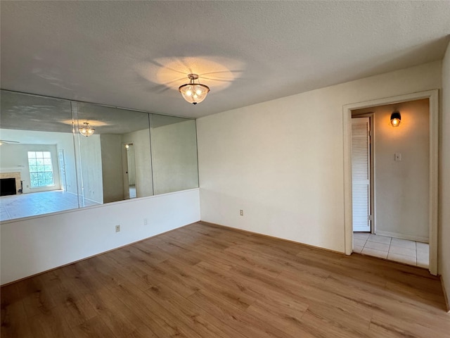 7400 Bellerive Dr Unit 1004, Houston, TX 77036 - spare room with wood finished floors, a textured ceiling, and a fireplace