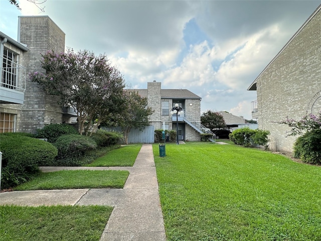 7400 Bellerive Dr Unit 1004, Houston, TX 77036 - view of front of house featuring a chimney, a front lawn, and stairs